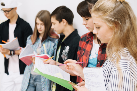 Youngsters With Notepads Studying