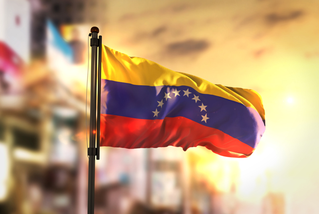 Venezuela Flag Against City Blurred Background Sunrise Backlight