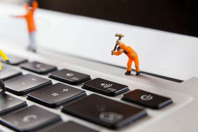 Miniature Workmen Repairing Laptop Keyboard