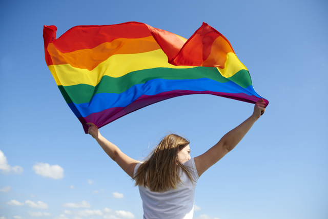 Rear View Young Woman Waving Rainbow Flag