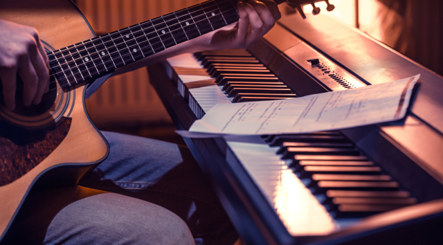 Man Playing Acoustic Guitar Piano Close Up Recording Notes Beautiful Color Background Music Activity Concept