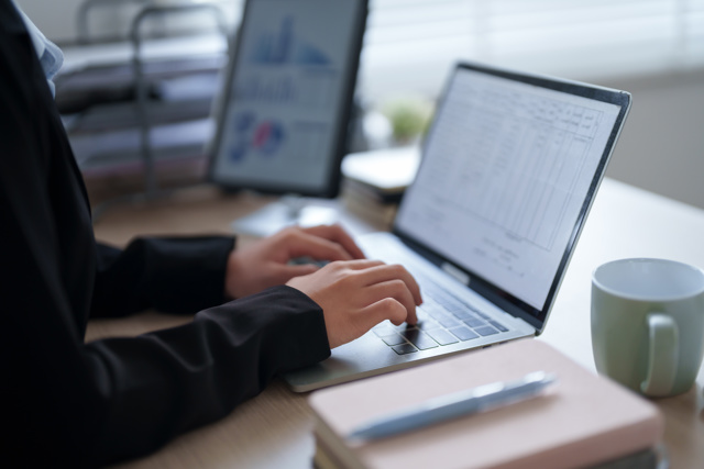 Professional Woman Black Suit Is Sitting Her Office Desk Focused Her Work With Laptop Surrounded By Office Supplies Documents