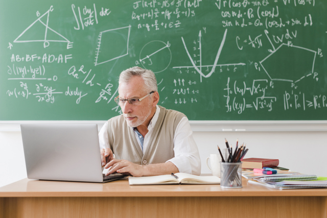 Old Teacher Using Laptop Classroom Image By Magnific