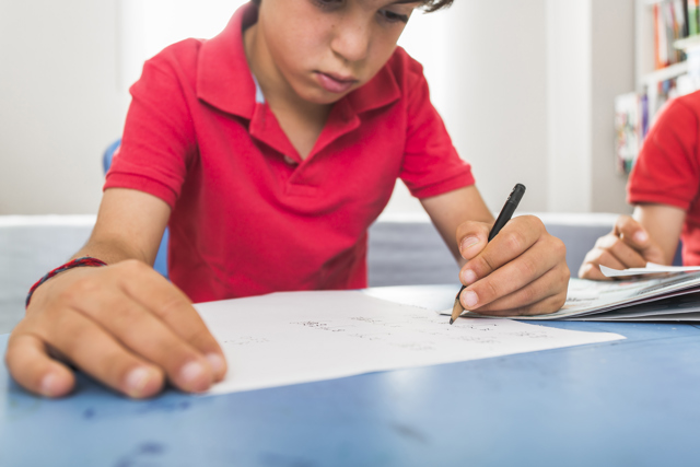 Kid Drawing With Pen Table